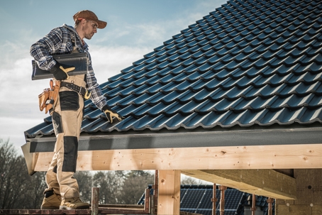 Male Worker Installing Roof Shingles.