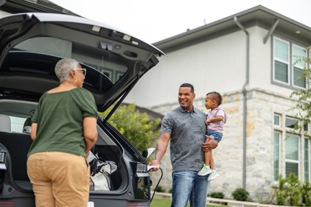 Family Charging Their EV and Unloading Car